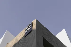 Modern building exterior made of concrete with angular geometric shapes.