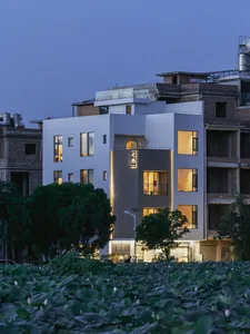 Modern residential building with a white concrete rendered exterior and glass walls