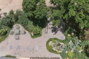 A modern residential garden features a combination of greenery, seating areas, and landscaping elements.