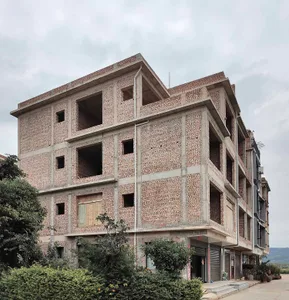 A brick building under construction with unfinished floors and open windows.