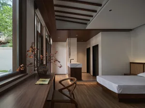 A modern bedroom with wooden furniture and a large window.