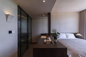 A modern bedroom with wooden furniture and minimalist design.