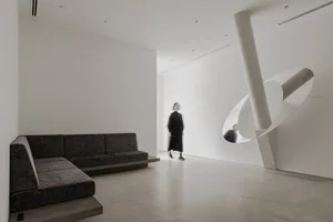 A modern interior space featuring concrete and glass materials.