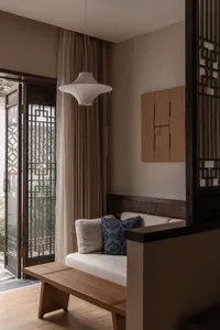 A modern living room featuring a wooden couch with cushions.