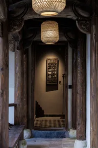 Traditional entrance hall with wooden columns, beams, and hanging lights.