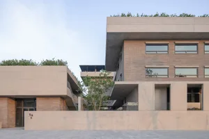 A modern building made of concrete with large windows and a minimalist design.
