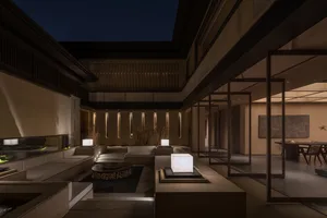 A modern living room with concrete and glass elements.