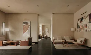 A modern living room with neutral tones, featuring minimalist furniture and abstract art.