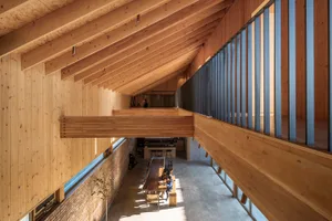 Industrial-style modern office space featuring exposed wooden beams and natural light.