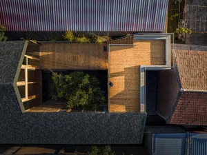 A modern roof deck with wooden flooring and a tree in the middle.