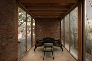 Industrial living space with brick walls, wooden furniture, and glass windows