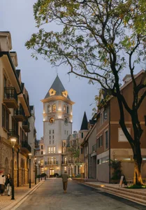 A street scene featuring stone, brick, and glass structures in a town square.