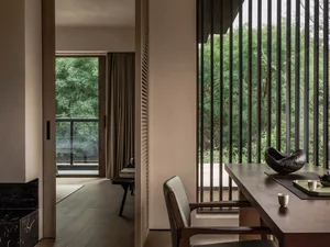 A minimalist residential interior design featuring wooden furniture and glass window panels.