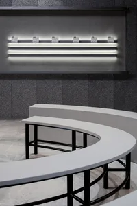 Modern minimalist interior with white benches and concrete floor and walls, illuminated by LED lighting, metal railings.