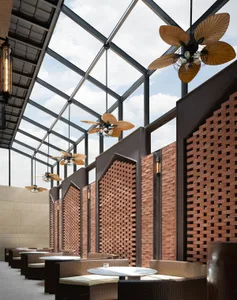 Industrial-style seating area with brick privacy walls and wicker furniture.