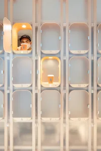 A minimalist office space featuring modern, glass-paneled lockers