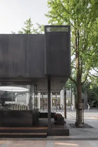 A modern building with a black metal exterior features a sleek, minimalist design.