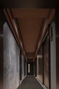 現代酒店走廊採用木質瓷磚與混凝土飾面，展現當代設計元素。