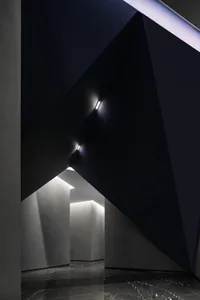 Modern interior design featuring concrete walls and ceiling in a corporate office entryway.
