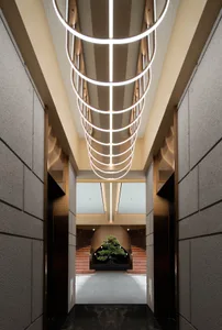 A modern lounge area featuring metal elements and geometric lighting fixtures.