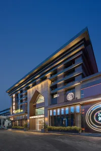 Modern shopping center with concrete, glass, and aluminum exterior during sunset.