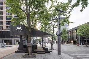 Modern urban architecture featuring metal, glass, concrete, and greenery