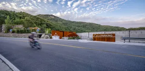 Mountain range with a road featuring concrete barriers and asphalt surface.