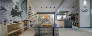 An industrial-style coffee shop interior with wood accents and black countertops.