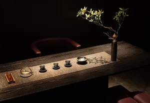 A beautifully arranged tea ceremony space featuring wooden elements and brass accents.