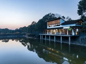 Modern residential house with white exterior located near a serene water body.