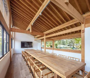 A spacious conference room with wooden tables and chairs surrounded by large windows.