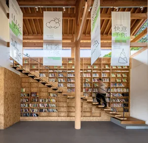 A spacious library with a staircase leading to multiple levels of bookshelves.
