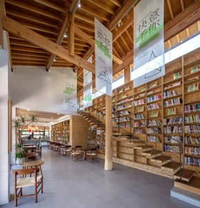 Industrial-style library with wooden shelves and staircase.