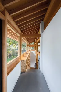 Interior of a modern house featuring wooden beams and concrete flooring.