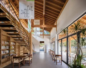 Modern library interior featuring wooden shelves and tables with a mix of reading materials.