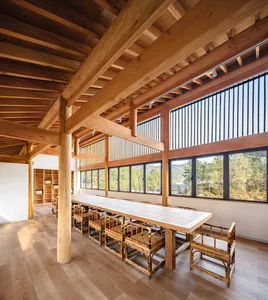 Modern restaurant interior with wooden ceiling and tables.