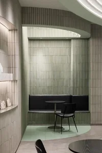 A minimalist cafe interior featuring rectangular tiles on the walls.