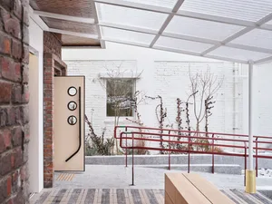 A modern entryway featuring brick, glass, and concrete materials.