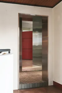 A modern interior entrance featuring metal framing and a glass door.