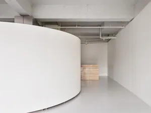 現代室內空間，白色混凝土牆面，極簡設計，裸露天花板橫樑。