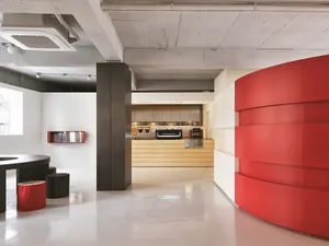 Modern restaurant bar featuring a red curved feature on a white floor and ceiling.
