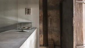 Minimalist interior design featuring a concrete wall with a glass box containing food items.