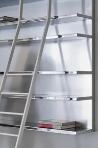 A metal shelving unit with a ladder on a white wall.
