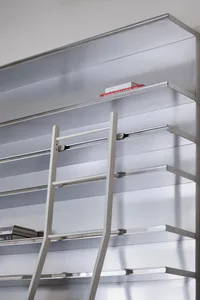 Metallic shelving system with a ladder in an industrial library setting.