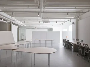 An empty, minimalist office space with white walls and furniture.