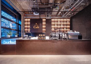 Modern metal coffee shop counter with industrial design elements and coffee-making equipment.