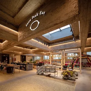 Modern industrial-style restaurant interior with concrete finishes and exposed concrete ceiling beams