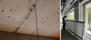 Construction site with visible concrete ceiling featuring multiple holes and visible cables attached.