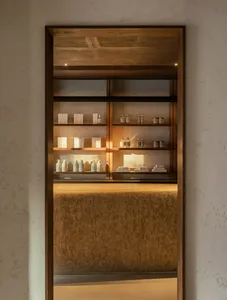 A modern retail storefront featuring wooden shelves displaying beauty products.