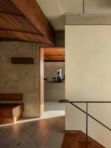 Interior of a modern coffee shop featuring a sleek bar counter made of wood and concrete with a minimalist design.
